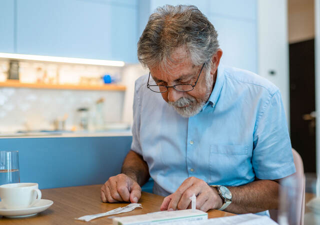 Man reading covid test kit instructions