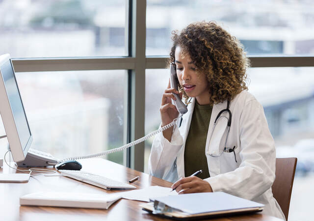 Doctor sitting at desk on the phone