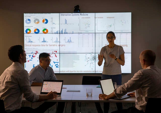 Meeting in front of a large information device about universal detection of genes in a specific biological sample.