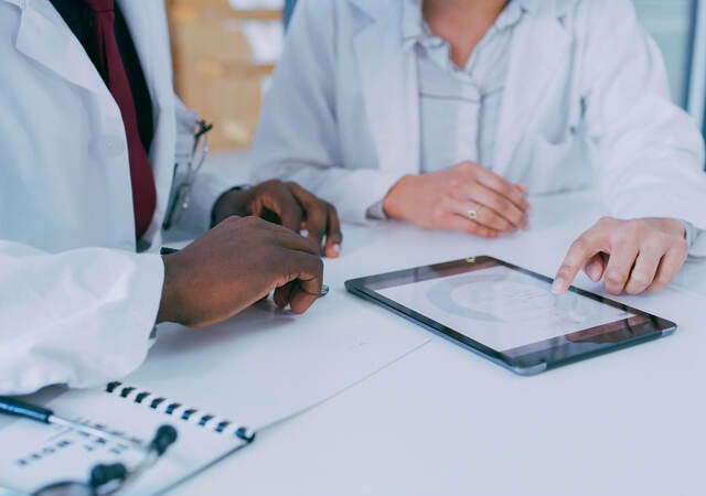 Two medical professionals using a digital tablet