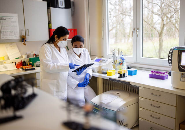 Two lab technicians looking at a clipboard