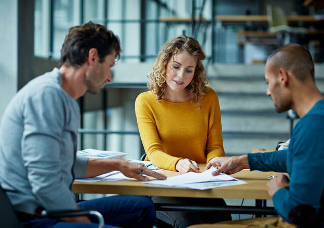 Three people at a table collaborating