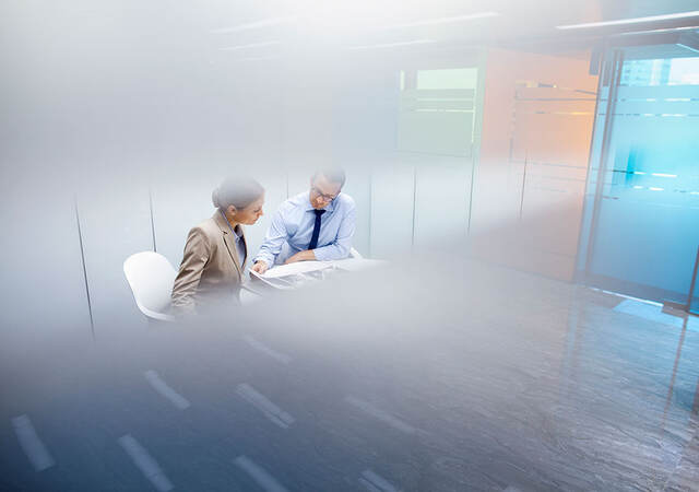 Two people reviewing a document in a conference room