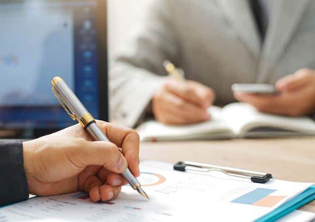 Two people taking notes