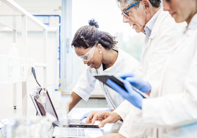 Lab techs working on a laptop