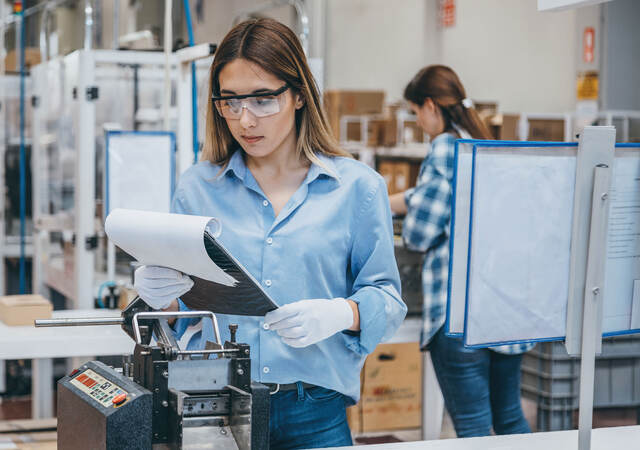 Technician in a lab reviewing notes