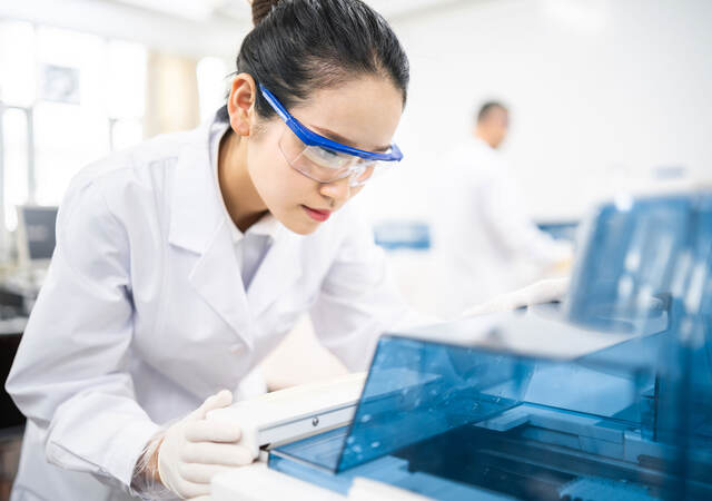 Lab technician wearing safety goggles staring at a test