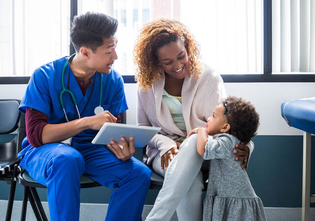 A nurse talking to a mother and child