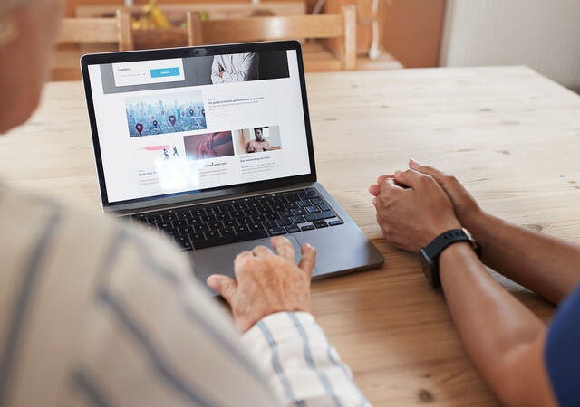 Two people using a laptop