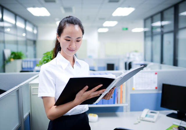 Person looking at documents in a binder