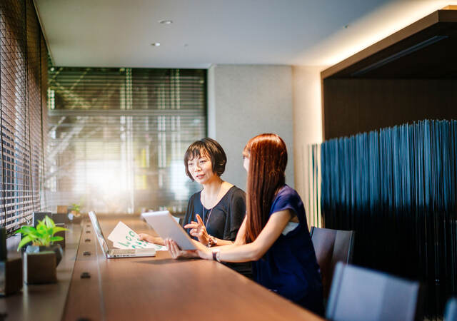 Two women comparing notes in an office