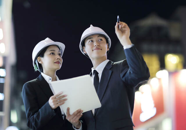 Two people in hardhats interacting