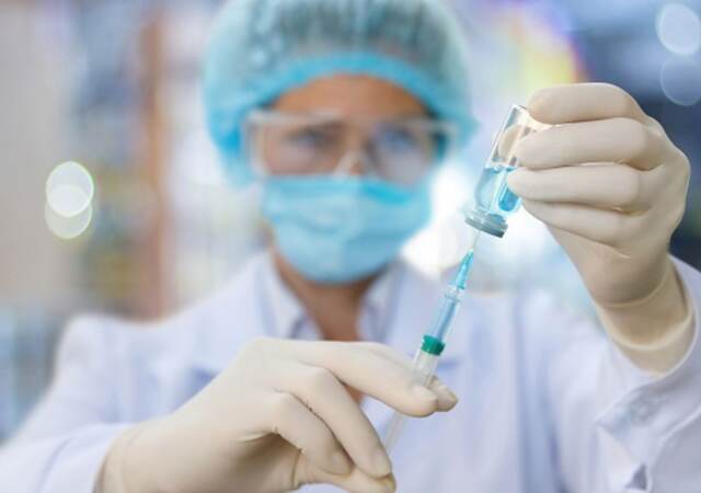 Nurse filling a syringe