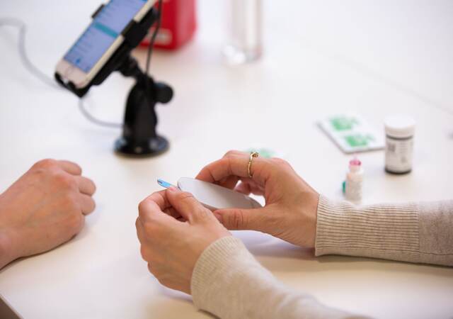 Person pulling a test strip out of a machine