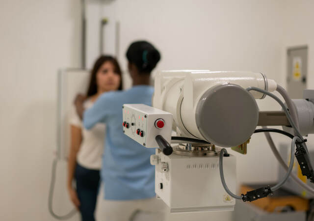 Nurse aligning a patient in order to take an x-ray