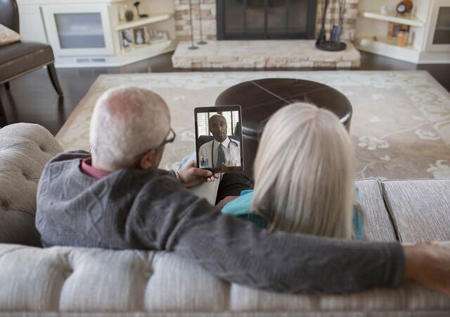 Two people having a virtual visit with their doctor