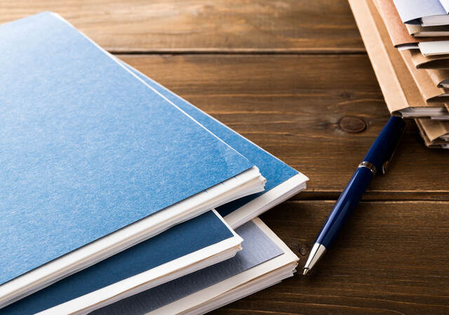 Folders, pen, and notepads on a table