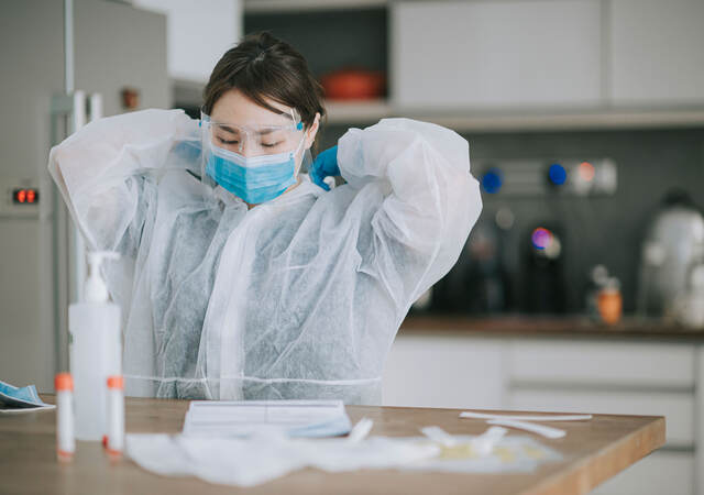 Scientist putting on PPE