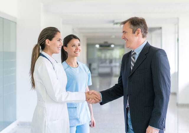 Doctor shaking a person's hand inside a hospital