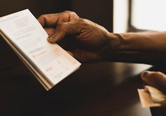 Close up of a hand holding an instruction booklet