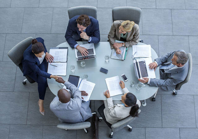 Overhead view of business people sitting around a conference table while working