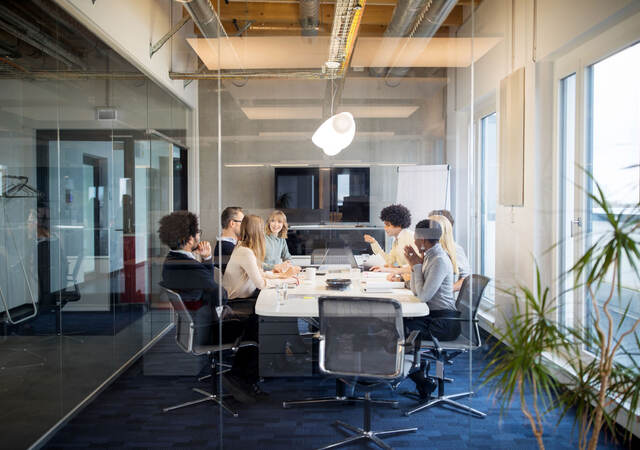 A board meeting inside a glass conference room