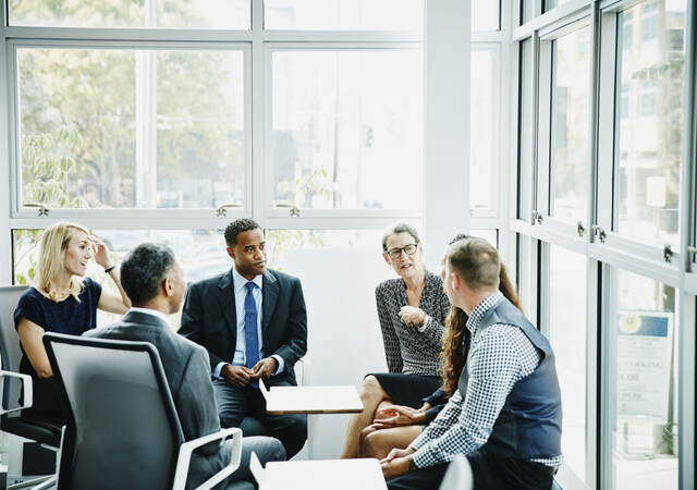 Group of business professionals having a discussion while sitting in a circle