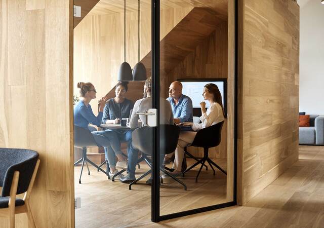 Business executives meeting inside a modern wood paneled conference room