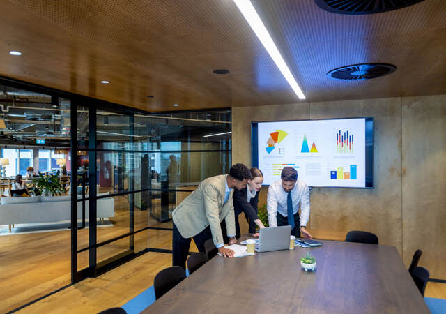 Three business colleagues reviewing metrics in a meeting