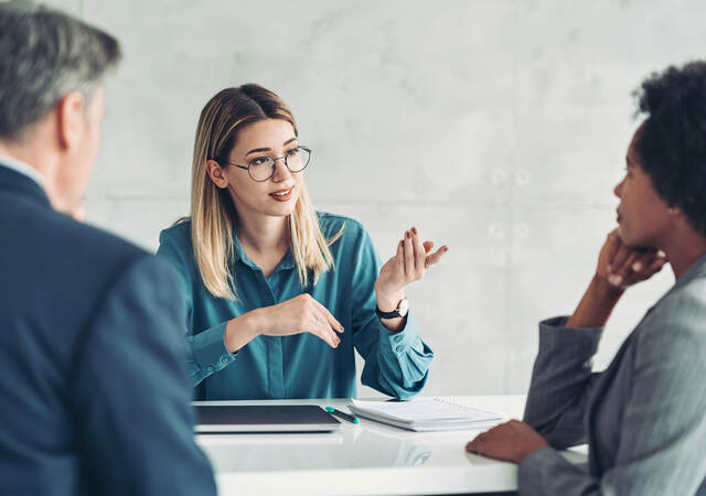 Three business professionals at a table having a meeting