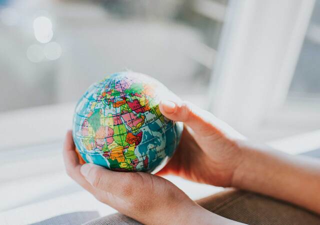 Hands holding a small globe