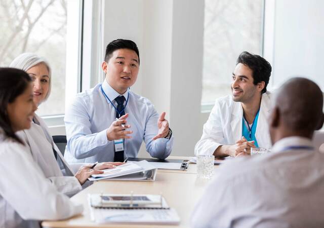 Group of medical professionals having a discussion around a table