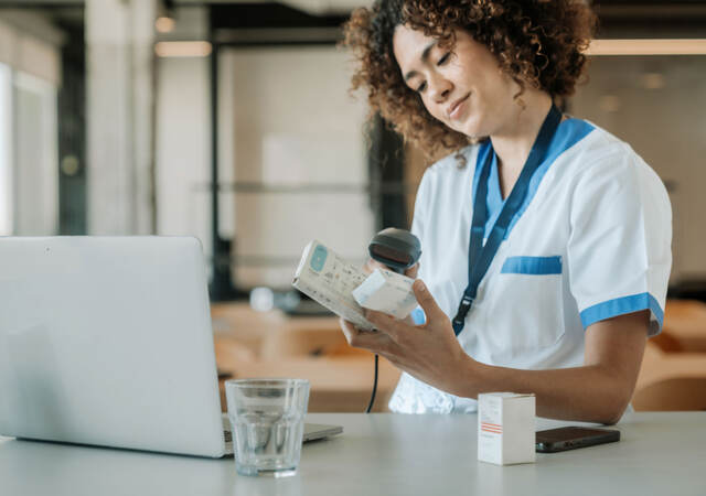 A technician scans the barcodes on medicine boxes