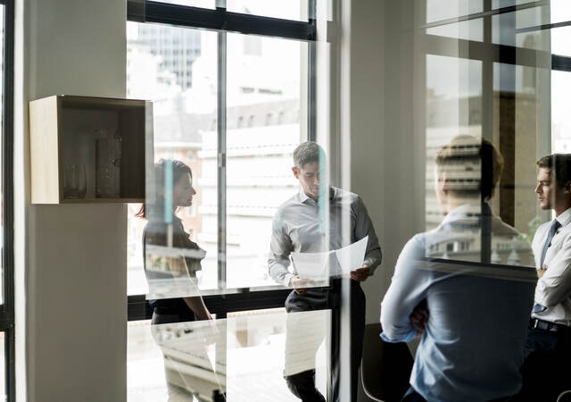 Business colleagues collaborating in a glass walled office