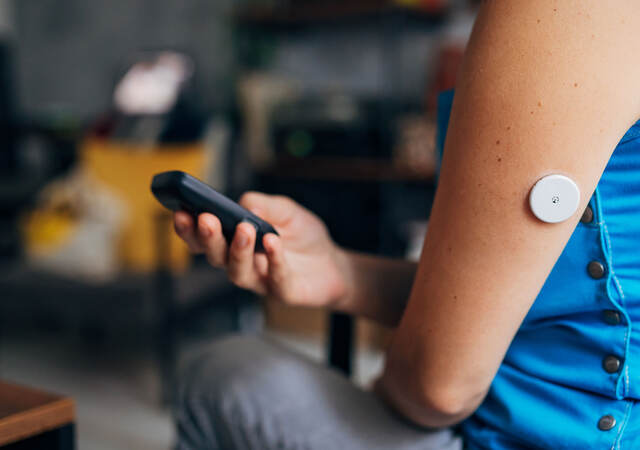 Person testing their blood sugar with wireless medical device