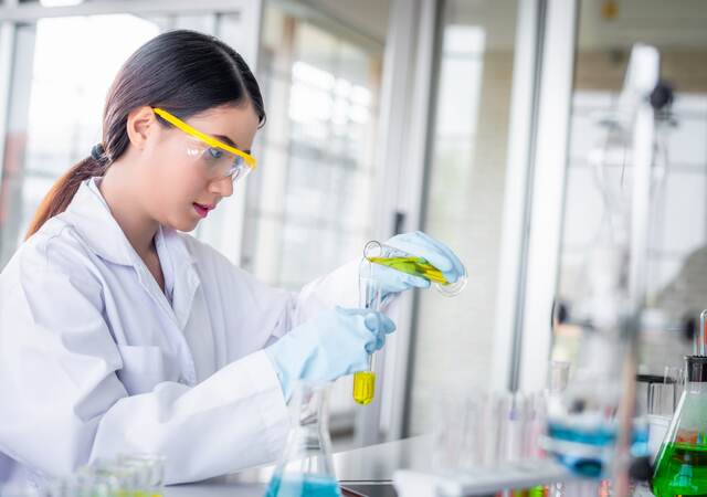 Scientist woman lab technical service observe liquid sample with lab glassware and test tubes in chemical laboratory