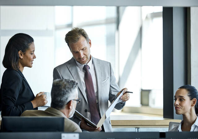 Business professional opening a portfolio to discuss it with colleagues