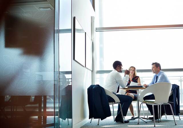 Three business people at a table having a meeting