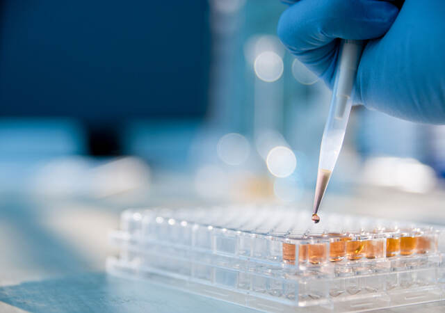 Closeup of a person pipetting a sample into vials