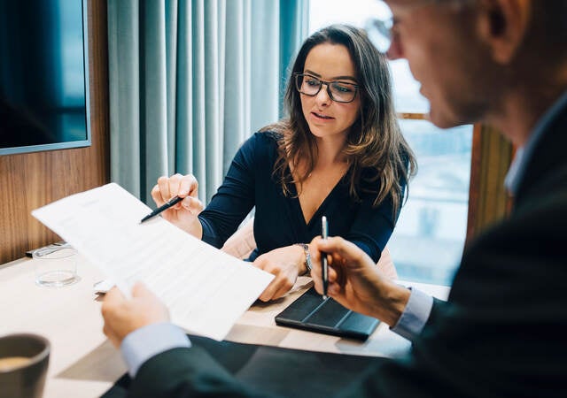 Two business professionals discussing regulations during a meeting