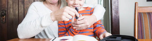 Mother helping son use medical device