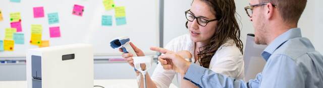 Two people in a conference room testing medical equipment