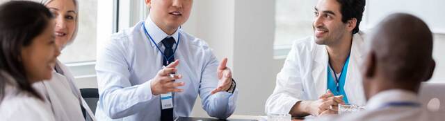 Group of medical professionals having a discussion around a table