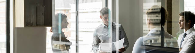 Business colleagues collaborating in a glass walled office