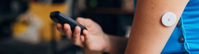 Person testing their blood sugar with wireless medical device