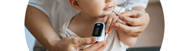 Doctor helping a baby use an oximeter