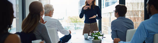 Person standing in front of a conference table to lead a meeting