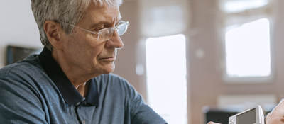 Senior using blood pressure machine in their home