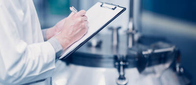 Scientist writing notes on a clipboard