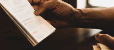 Close up of a hand holding an instruction booklet